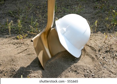 A Hard Hat And Golden Shovel Await  Their Use In A Groundbreaking Ceremony.