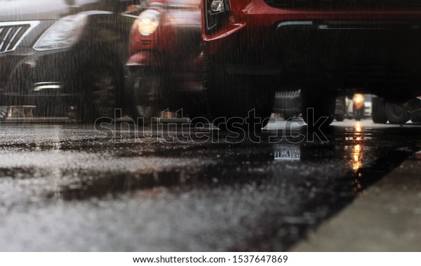 Hard rain fall in the city with blurry cars\
.Selective focus.