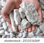 Hard rock spodumene ore, commercially important source of lithium. Mine, mining. Held in human hand. Copy space.