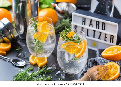Hard seltzer cocktail with orange, rosemary and bartenders accessories - Shutterstock ID 1933047041