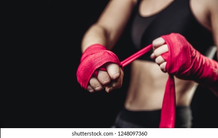 Hard Sport Woman Ready For Fight. Fighter Girl In Sports Top, Red Elastic Bandages Fists On Black Background