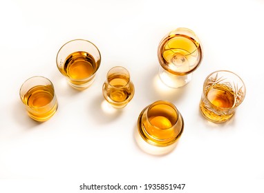 Hard strong alcoholic drinks, spirits and distillates in glasses: vodka, cognac, tequila, scotch, brandy and whiskey, grappa, vermouth, rum. White background 