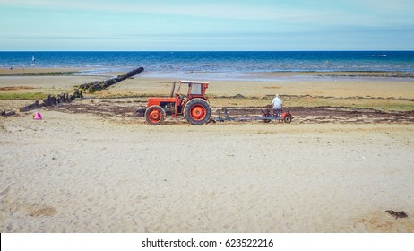 Hard work, Tractor and driver facing the sea.