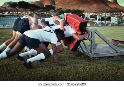 Hardcore rugby training. Cropped shot of a group of young rugby players training with tackle bags on the field during the day. - Powered by Shutterstock