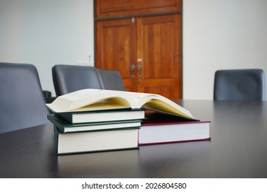 Hardcover Law Books Stack And Open Book On Meeting Table In Blur Office Room Background, Pile Of Books