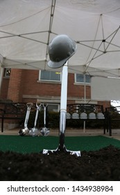 A Hardhat Rests On A Shovel In Preparation For A Groundbreaking Ceremony.