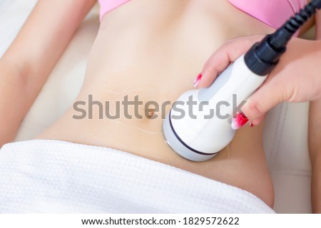 Hardware cosmetology. Body care. Spa treatment. Ultrasonic cavitation body contouring treatment. A woman receives anti-cellulite and anti-fat therapy in a beauty salon.