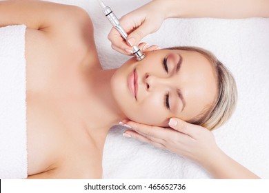 Hardware cosmetology. Closeup portrait of female face with closed eyes getting microdermabrasion procedure in a beauty parlour.