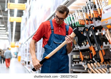 Hardware Store Clerk Looking At The Markings On The Axe.