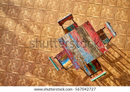 Hardwood interior and decor. Top view of colorful wooden table and chairs in cafe.