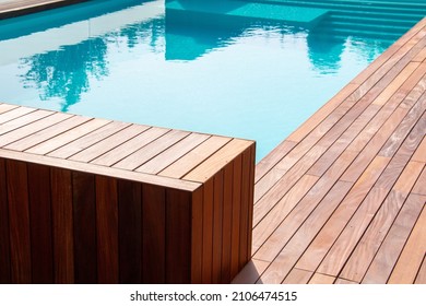 Hardwood ipe pool deck on direct sun heat, summer swimming pool decking design idea - Shutterstock ID 2106474515