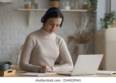 Hardworking College Student Girl Preparing For Test, Exam At Home, Watching Webinar, Virtual Lecture, Attending Online Class, Writing Essay, Summery, Notes, Using Laptop At Kitchen Table