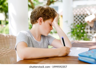 Hard-working Sad School Kid Boy Making Homework During Quarantine Time From Corona Pandemic Disease. Upset Tired Child On Home Schooling In Coronavirus Covid Time, Schools Closed.