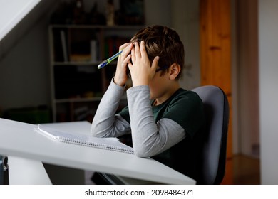 Hard-working Sad School Kid Boy Making Homework During Quarantine Time From Corona Pandemic Disease. Upset Tired Child On Home Schooling In Coronavirus Covid Time, Schools Closed.