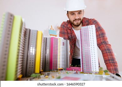 Hard-working Young Caucasian Architect Man Working In Office With Drawings And Small Building Model. Isolated In Workplace, White Office