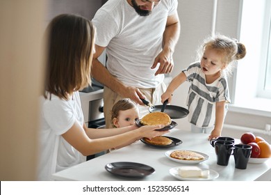hardworking young girl helping her parents to cook pancakes. close up photo