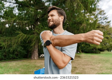 A hardy man uses a smartwatch and a fitness app. A sporty man in sportswear is running. A runner doing a workout exercise jogging. - Powered by Shutterstock