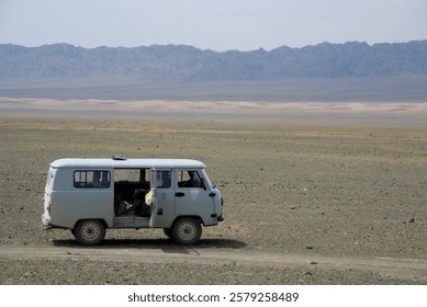 A hardy Russian UAZ-452 surrounded by wide open plains near the Gobi Desert, Mongolia