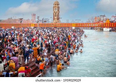 HARIDWAR, UTTARAKHAND, INDIA - APRIL 2021: A large group of Indian devotees take part in a holy bath on the occasion of Kumbh Mela which happens once in 12 years. Har Ki Pauri Ghat. Selective focus.