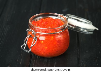 Harissa In A Jar On A Dark Rustic Background.