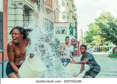 Harlem, New York - 07/21/2015: African American Young People Having Water Fights In Summer, Harlem Neighbourhood, New York City