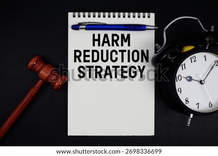 Harm Reduction Strategy text written on notepad with gavel and alarm clock on black background