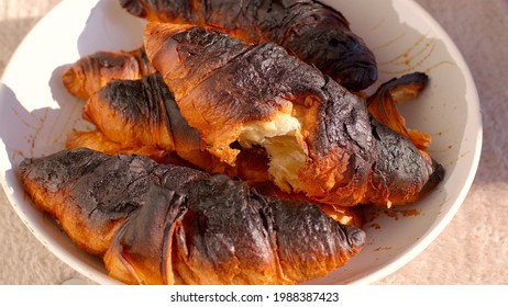 Harmful Food Carcinogens. Burnt Croissants On Plate. Baking Error, High Oven Temperature. Black Burnt Crusts. 