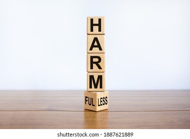 From harmful to harmless. Turned the wooden cube and changed word 'harmful' to 'harmless'. Beautiful wooden table, white background. Business and harmful or harmless concept. Copy space.