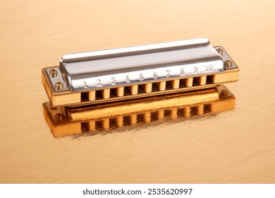 The harmonica lies on a mirrored surface. Classical musical wind instrument. - Powered by Shutterstock