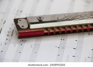 A harmonica on a piece of sheet music. - Powered by Shutterstock