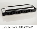 Harmonica on a white background, a classic musical instrument ideal for jazz, blues and folk music.