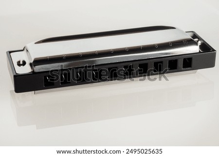 Harmonica on a white background, a classic musical instrument ideal for jazz, blues and folk music.