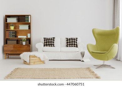 Harmonious and elegant living room decor, with a renovated modernist bookcase and a green egg chair
