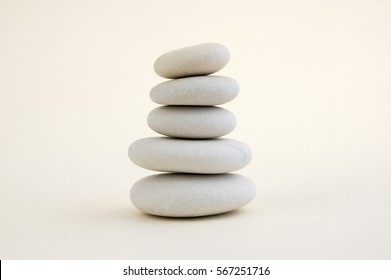 Harmony and balance, cairns, simple poise stones on white background, rock zen sculpture, five white pebbles, single tower, simplicity