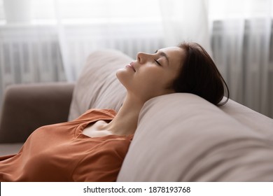 In harmony with myself. Serene millennial woman spending time at home taking break for rest relax. Tranquil young lady lean back on couch in comfortable pose, dream with closed eyes, breath fresh air - Shutterstock ID 1878193768