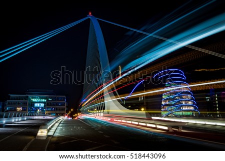 Harp bridge in Dublin with cars passing through by night