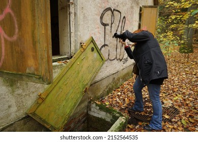 HARPSTEDT, GERMANY - Nov 11, 2018: A Closeup Of A Person Photographing Abandoned Building With Graffiti In Germany