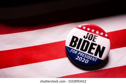 Harrisburg, PA - November 7, 2019 - Joe Biden Presidential Campaign Button Against US Flag. Selective Focus, Shallow Depth Of Field.