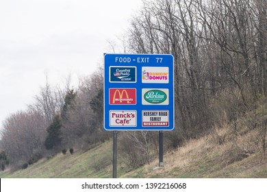 Harrisburg, USA - April 6, 2018: Rural Pennsylvania Countryside In Spring With Blue Exit Sign On Highway For Food With Dunkin Donuts, Mcdonalds