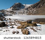 Harrison Stickle and frozen stickle tarn in Winter snow, Langdale Pikes, Langdale, English Lake District National Park, Cumbria, England, UK