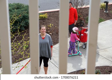 Harrisonburg, VA, USA - 4/5/2020: Young Family Visits Grandparents Up On A Balcony At A Retirement Community Apartment Building During Coronavirus Pandemic.