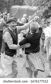 Harrogate, North Yorkshire, UK.6.17.2020.Happy man dancing with a woman at The Valley Gardens on a 1940's day. 