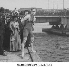 Harry Houdini jumps 30 feet from Harvard Bridge locked up in chains, April 30, 1908. Boston, Massachusetts. His hands were handcuffed and chained to a collar around his neck by a Boston policeman in f