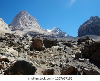 Harsh Mountain Landscape At High Altitude. Taken On The Way To Alaudin Pass In The Fann Mountains (Pamir, Tajikistan). Mid-August. Huge Rocks, Boulders And Bare Peaks. Blue Sky, No People.