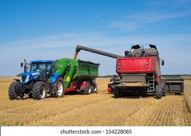 Harvest machine loading seeds in to trailer - Shutterstock ID 154228085