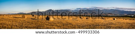 Harvested Field with Hay Bales in Golden Evening Light Under Low Tatras Mountains, Slovakia