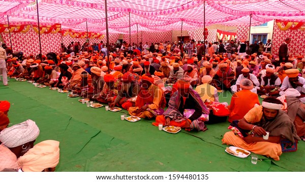Haryana, India –\
February 11, 2018: Group of Indian sadhu or religious saint sitting\
together in a row & having lunch together during religious\
event.                