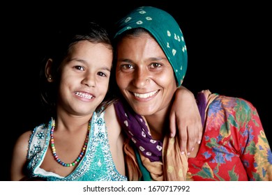 Haryana, India - September 14, 2014: Cheerful mother & child portrait together isolated on black background.