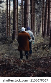 HARZ, GERMANY - May 15, 2022: A Vertical Shot Of Two Guys Seen From Behind, Walking In A Pine Forest