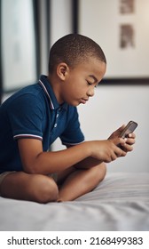 It Has No Cell Service But Can Connect To The Wifi. Shot Of A Young Boy Using A Cellphone While Sitting On His Bed.